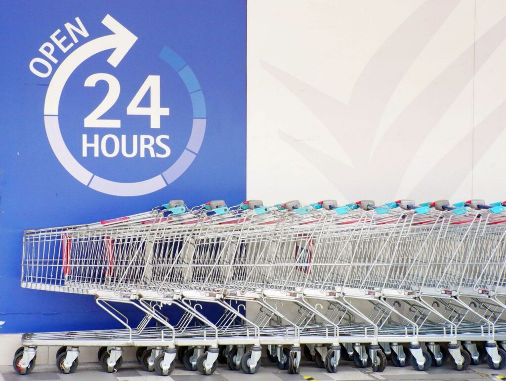 Row of shopping trolleys outside a 24-hour supermarket in Singapore, emphasizing convenience and accessibility.